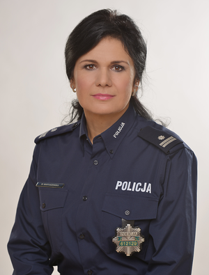 Rzecznik prasowy KPP Kłodzko- podinsp. Wioletta Martuszewska. Policjantka w galowym mundurze na szarym tle. Zdjęcie skadrowane do pasa. 